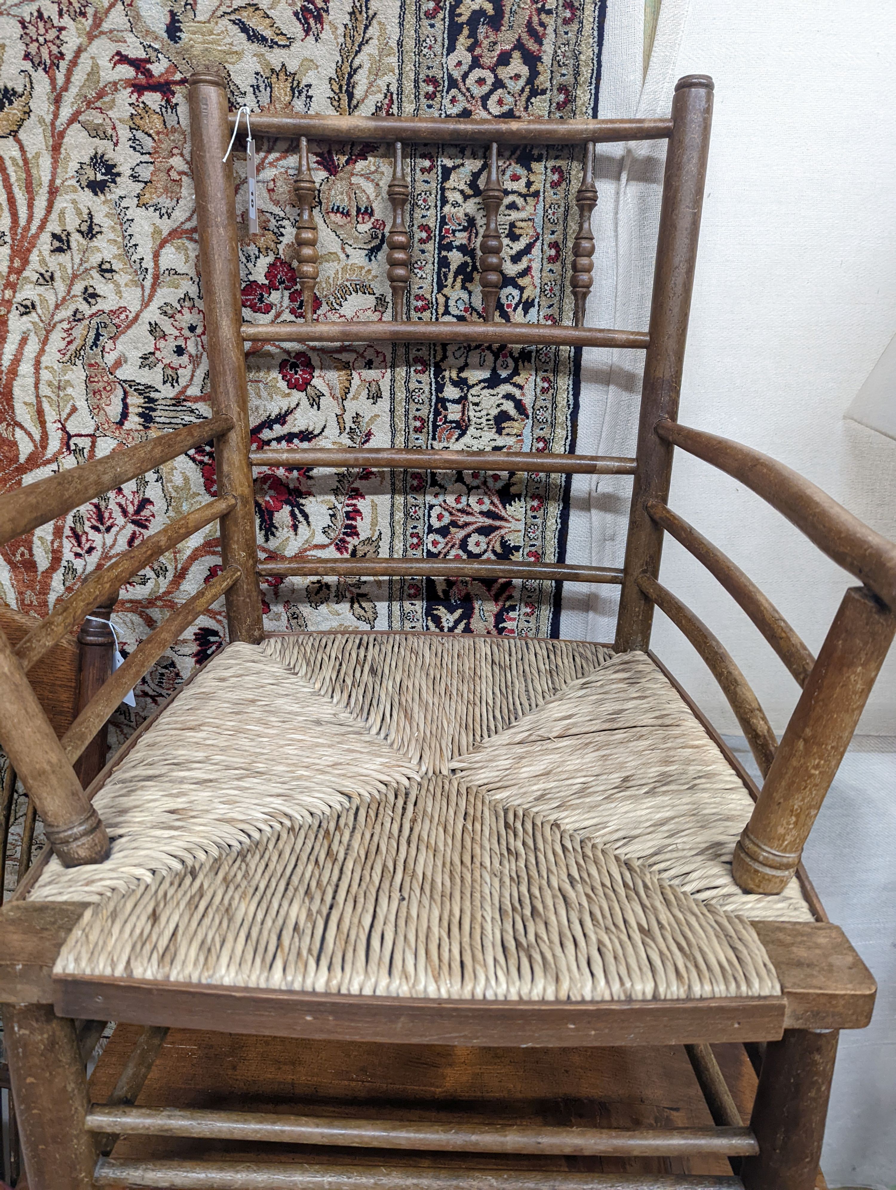 A late 19th century beech rush seated Sussex elbow chair, (cut down) width 55cm, depth 44cm, height 81cm